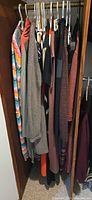 Closet rod with multiple sweaters and shirts showing patterns and colours