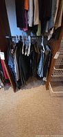 Assortment of pants hanging on lower closet rod