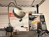 Project Source LED desk lamp, Panasonic cordless phone, Donvier ice cream maker visible on shelving