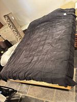 Top view of queen platform bed frame with dark blanket showing overall size and design