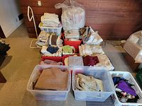 Overall view of multiple totes and baskets filled with folded household textiles