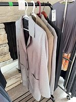 Four jackets hanging on rack, showing colors and styles