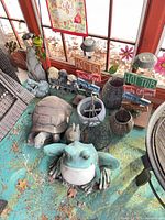 Group shot of garden decor items including animal statues, hot tub signs, lantern and planter