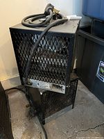 Two stacked metal-cage heaters with cords visible