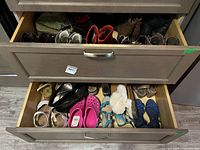 Two drawers open showing multiple pairs of boots, flats, sandals and slippers