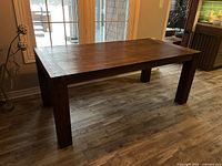 Full view of rectangular dark brown wood dining table with block legs