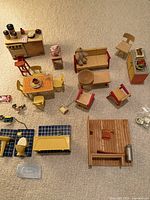 overview of dollhouse furniture and accessories laid out on floor