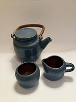 Teapot, creamer and sugar bowl grouped to show size and matching glaze