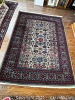 Full view of Persian rug showing overall pattern and borders