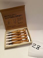 Set of five Power Grip carving chisels in open box on white surface