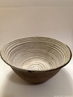 Three-quarter view of bowl showing ribbed glazed interior and brown exterior