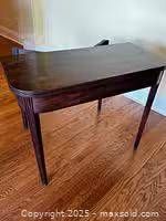Table folded showing overall form, mahogany finish, tapered legs