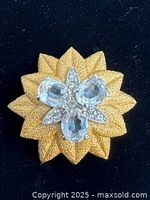 Front view of gold-tone floral brooch with clear stones