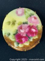 Front view showing painted roses and brass prongs