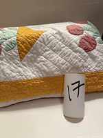 Folded quilt showing yellow border and tulip motif