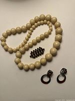 Necklace, brooch and earrings laid out