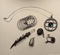 Full layout of six vintage jewellery pieces on surface