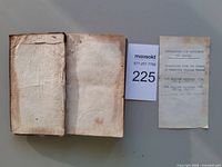 Closed leather-bound book alongside seller info slip