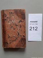 Front view of closed book showing marbled boards and wear