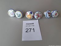 All six floral ceramic knobs front view with size reference card