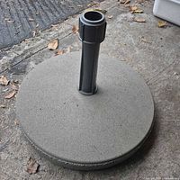 Top view of round concrete umbrella base with black pole holder