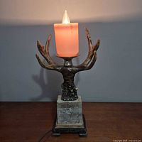 Full view of faux antler candle-style table lamp powered on