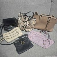 All six handbags arranged on sofa