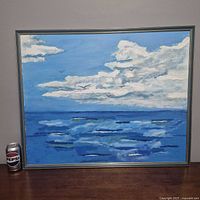 Full view of framed ocean painting beside soda can for scale