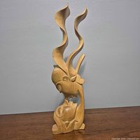 Front view of entire wooden kissing couple sculpture
