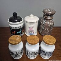 Front view of all six canisters showing lids and decoration