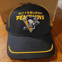 Front view of black and yellow Adidas Pittsburgh Penguins hat