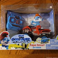 Retail package showing Papa Smurf on ATV and remote