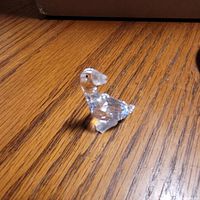 Faceted crystal goose figurine front-side view on wood surface
