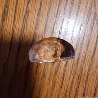 Front view of half-moon crystal paperweight showing etched peacock