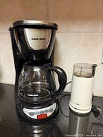 Front view of Black & Decker drip coffeemaker and Braun grinder on countertop