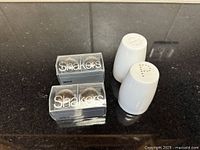 All shakers displayed: two boxed sets and two white ceramic pieces