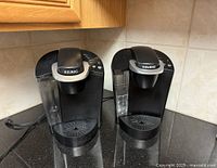 Front view of both Keurig coffee makers showing overall design and condition