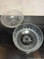 Both clear glass serving bowls side by side showing overall shapes and patterns