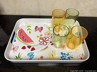 Tray, stack of plates, four tumblers displayed