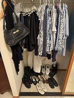 Full closet view with hanging garments, handbag and footwear