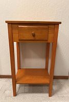 Front view of wooden nightstand showing drawer and shelf