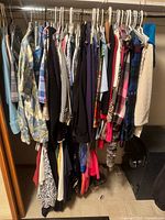 closet rod filled with women’s apparel on hangers showing variety of garments and colors