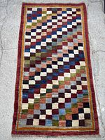 Full view of Gabbeh rug showing entire checkered design and borders