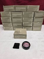 Stack of 20 boxed powders plus one open compact and applicator