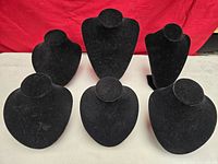 Six black velvet necklace display stands grouped together