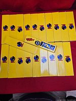 Twenty yellow Dick Tracy watch boxes with one opened to show watch and bezels