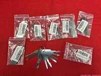 All seven sealed packs plus one ring of keys displayed on red background