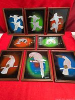 All eight framed reverse-glass paintings displayed together