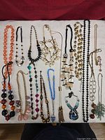 Full overview of all necklaces laid out on white surface