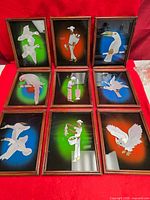 Full set of nine framed mirror pictures displayed on red cloth